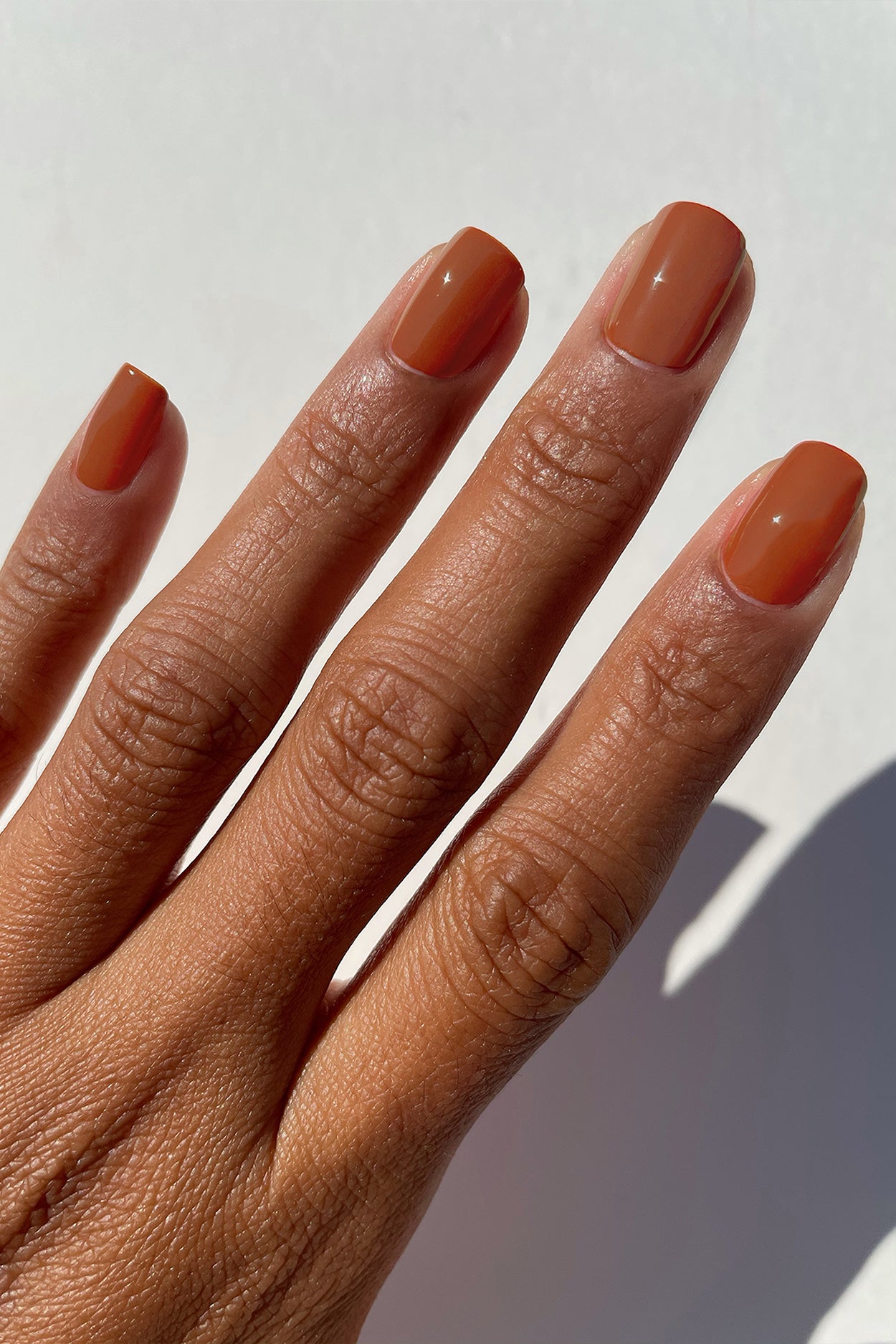 Premium Photo | Orange nail polish on long nails on a dark background.
